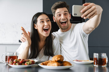 Young couple eating breakfast in the kitchen