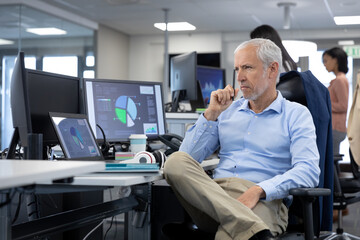 Thoughtful Senior businessman sitting on his desk at modern office