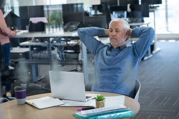 Senior businessman with eyes closed relaxing on chair at modern office