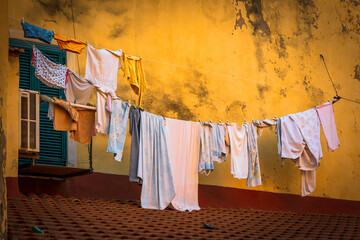Wäsche zum Trocknen an einer maroden Hauswand, Italien
