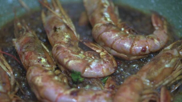 Shrimps fried in pan in olive oil and soy sauce. Close-up. HD