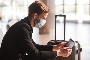 Man wearing a face mask while waiting for a flight