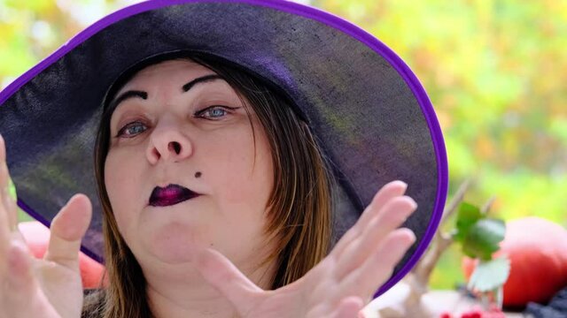 witch in a black copack prepares a green witch's potion, makes magic passes, the concept of the Halloween holiday, love spell, clairvoyance, party preparation