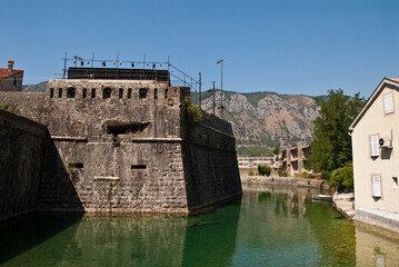A river flowing along the fortress wall, originating in the mountains