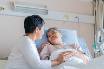 Fototapeta premium Happy lover woman Visits Best friends holding hand for recovering sick lying in Hospital, looking with cheerful love hopeful emotional,Encouragement comforting Recovering from family healthy moment