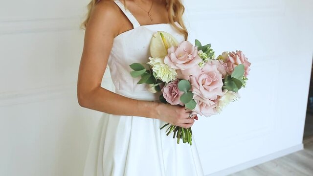 female hands a gift bouquet of flowers Bride in white dress Woman blonde

