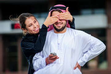 Obraz premium Arabic couple posing outdoors with mob phone in the hands.