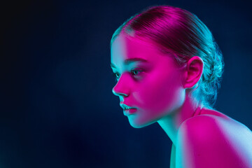 In love. Portrait of female fashion model in neon light on dark studio background. Beautiful caucasian woman with trendy make-up and well-kept skin. Vivid style, beauty concept. Close up. Copyspace