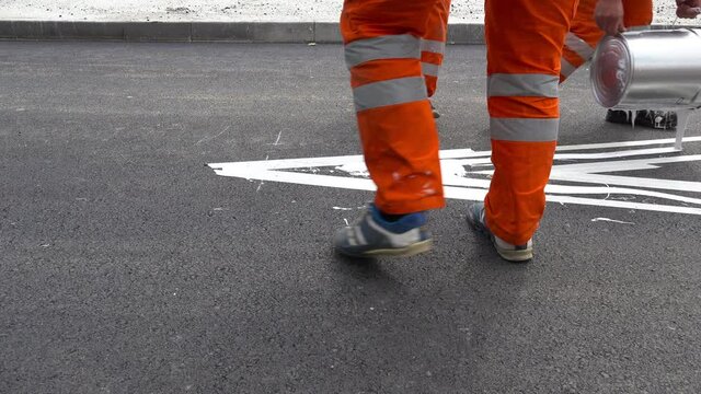 Painting traffic road sign on asphalt street.