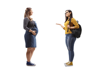 Full length profile shot of a pregnant woman and a female student having a conversation