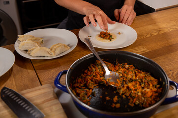 Detail of hands preparing dumplings