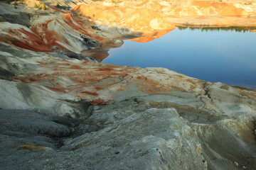 quarries in the place of mining and red refractory clay against the backdrop of red clay mountains and quarries