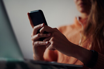 Closeup of young woman hands holding and using smartphone at home during quarantine
