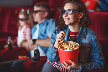 Family mom father and children are watching a projector, TV, cinema, movies with popcorn in the cinema. High quality photo.