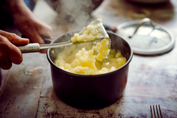 Mashed potatoes in a pot with steam and process