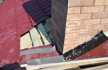 A close-up on a roofing construction, installation of metal roof tiles on wood roof sheathing...