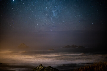 night view of a rocky beach with stars