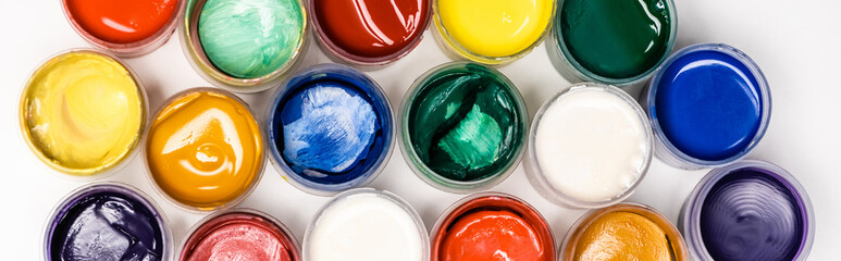top view of colorful Gouache paints on white background, panoramic shot