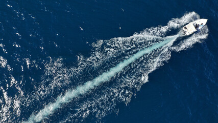 Aerial bird's eye view photo taken by drone of boat cruising in caribbean tropical beach with...