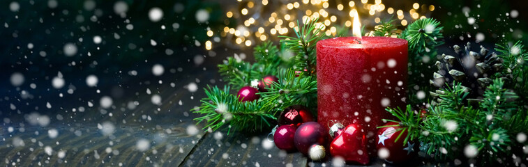 Christmas decoration - red advent candle with beautiful gold bokeh light and falling snowflakes -...
