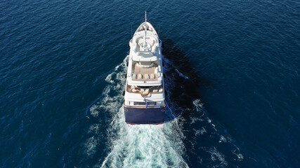 Aerial drone photo of luxury yacht with wooden deck cruising deep blue Aegean sea near island of...