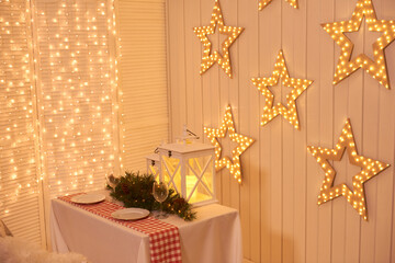 Dining room decorated for Christmas. Table with chairs set, waiting for guests. The wall is...