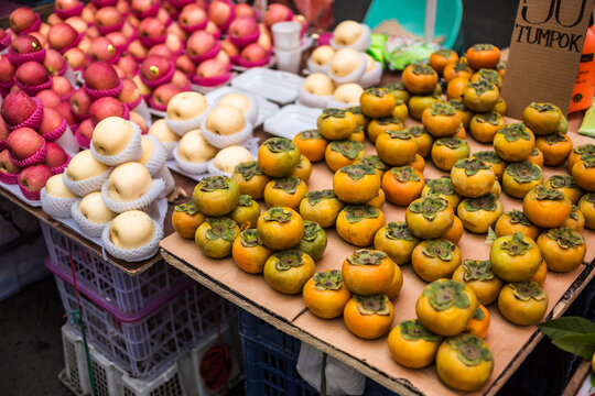 Apples, peaches and persimmons for sale at a street market in Divisioria, Manila, Philippines