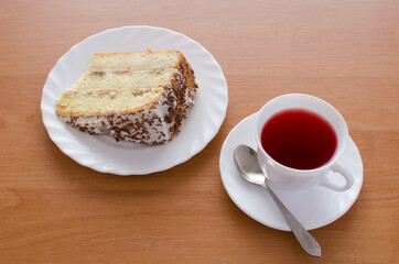 One white cup of tea and cake.