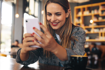 Woman texting on her mobile phone at cafe
