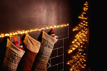 Beautifully decorated Christmas socks hanging on a painted fireplace waiting for presents