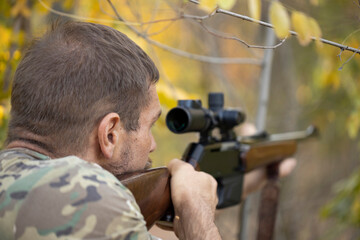 Close up image of male shooting rifle. Image taken during big game hunting trip. Hunting period, autumn season open.