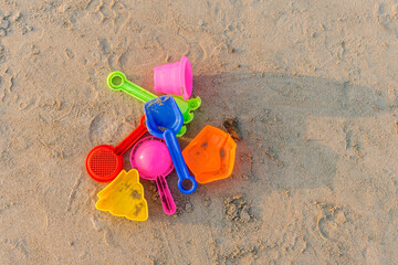 Bright colorful children's toys on the sandy beach