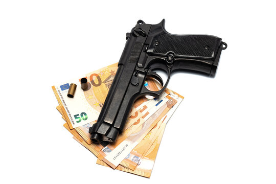 Bunch of euro banknotes, gun and empty bullet cartridges. Isolated on white. Crime, violence concept
