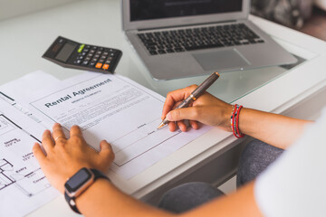 Woman signing new rental agreement contract.