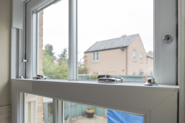 Detailed view of a newly installed, energy saving double glazed sash window looking to  small patio area.