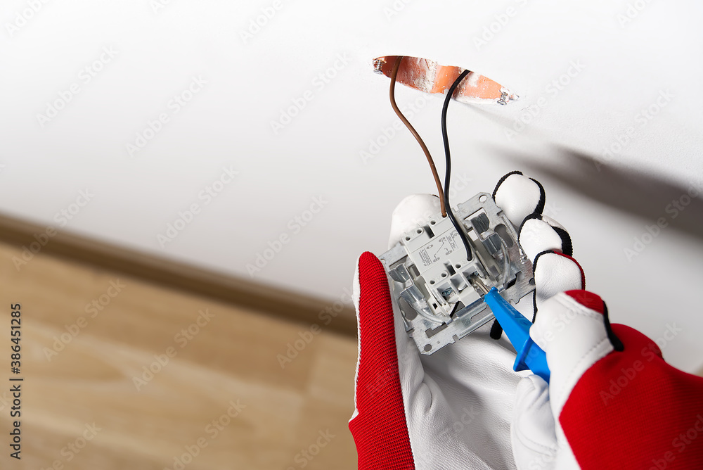 Poster electrician installing light switch on painted wall with screwdriver. man installing light switch af