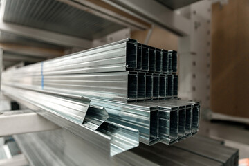 Stack of galvanized rectangular steel pipes for building materials. Production and construction of...
