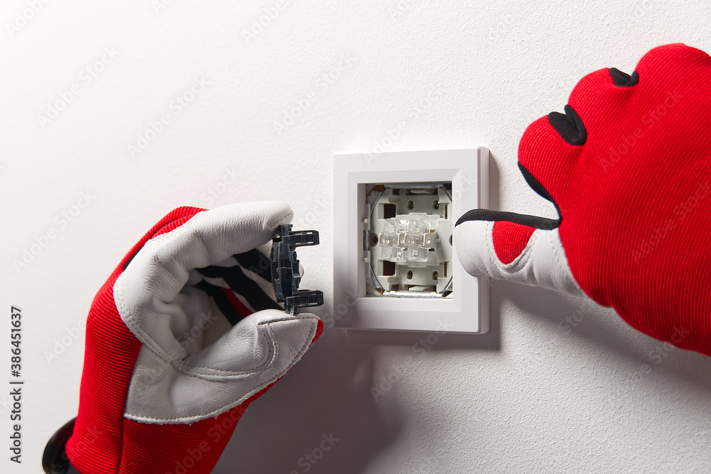 Poster electrician installing light switch on painted wall with screwdriver. man installing light switch af