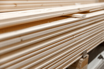 Wooden boards for building materials are stacked and wrapped in packaging material( polyethylene). Soft focus