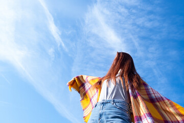 portrait of a red-haired girl in a scarf on a blue sky