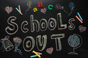 Pieces of chalk, stationery and text SCHOOL'S OUT written on blackboard, flat lay. Summer holidays