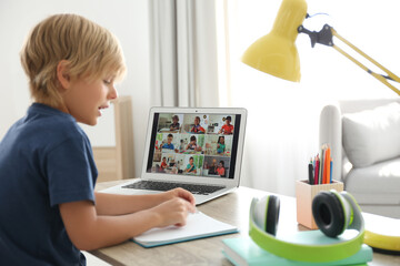 Little boy studying with classmates via video conference at home. Distance learning during COVID-19...