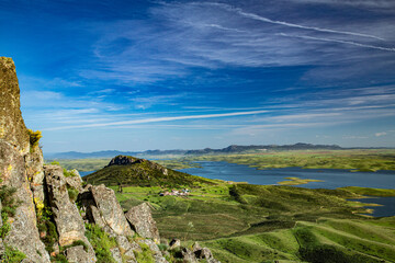 Landscape of green farm fields with hills and water reservoir