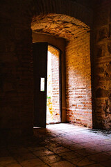 Wooden door in castle interior with red brick walls