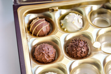 a box of round belgian or swiss chocolate candies, top view of praline closeup