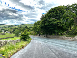 View along, Stansfield Brow, with trees,  and hills, leading to the village of, Lothersdale, Keighley, UK