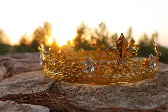 mysterious and magical photo of gold king crown in the England woods over stone. Medieval period concept.