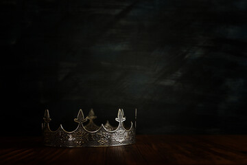 low key image of beautiful queen/king crown over wooden table. vintage filtered. fantasy medieval period