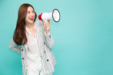 Young Asian woman holding megaphone isolated on green background, Speech and announce concept
