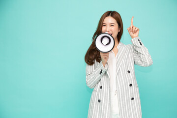 Young Asian woman holding megaphone isolated on green background, Speech and announce concept